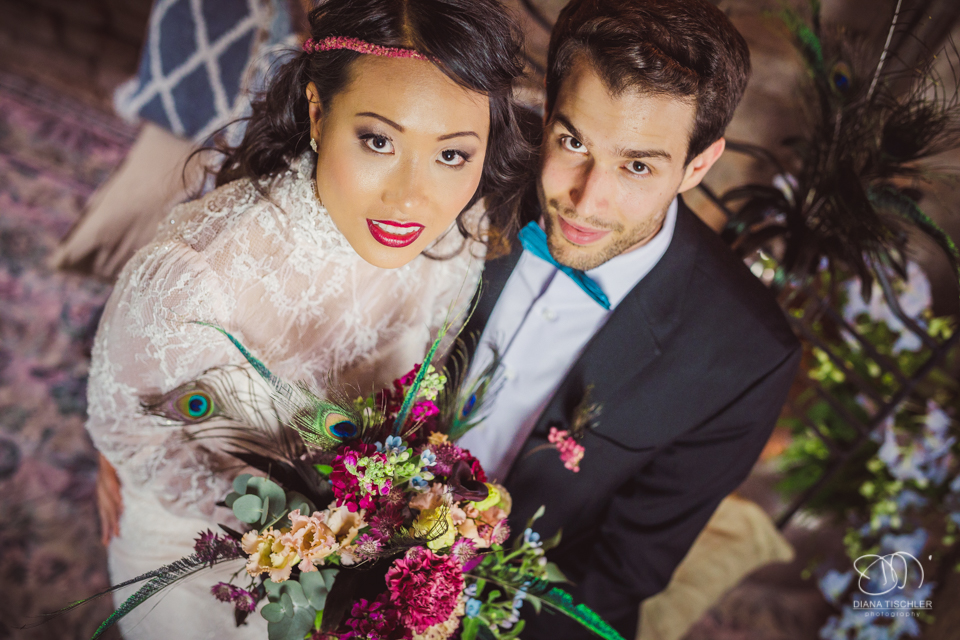 Braeutigam und Braut mit tollem buntem Brautstrauss bei einer Hochzeit in einer Scheune