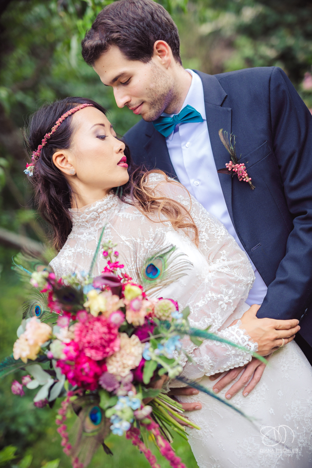 Braeutigam und Braut mit tollem buntem Brautstrauss und mit romantischem vintage Boho Kleid bei einer Hochzeit in einer Scheune