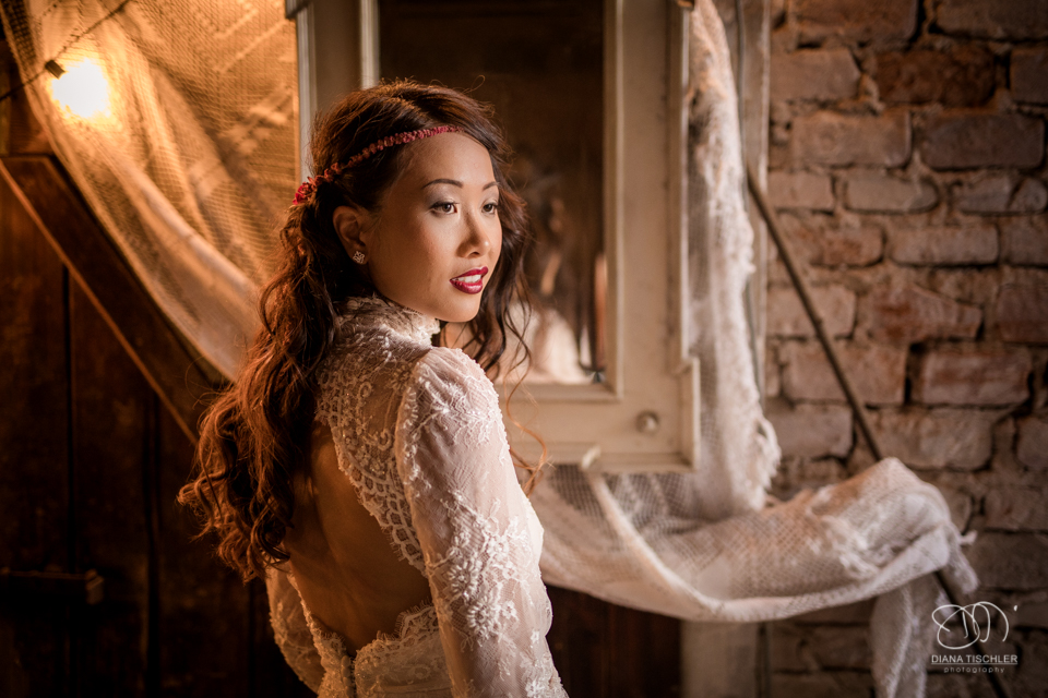 Braut mit tollem vintage Boho Kleid im Kerzenlicht bei einer Hochzeit in einer Scheune