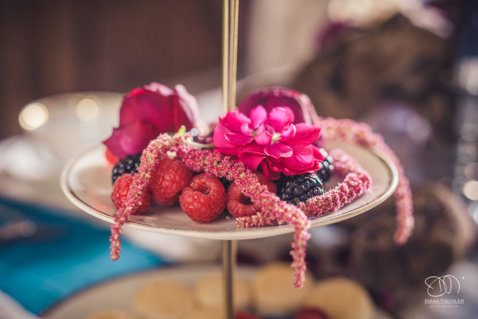 Beeren und Blumen auf einer Etagere fuer eine Hochzeit in einer Scheune
