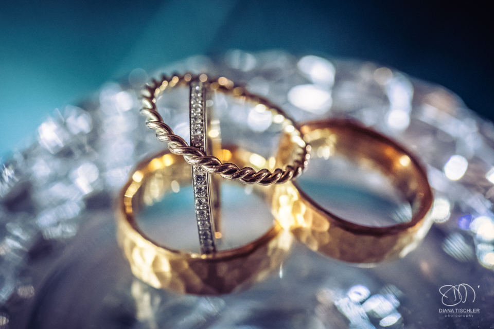 goldene Eheringe mit Verlobungsring bei einer Hochzeit in einer Scheune