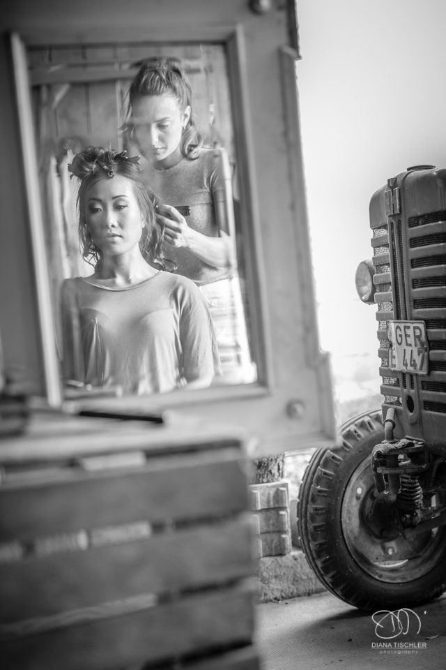 Getting Ready Braut-Frisur im Spiegel fuer eine Hochzeit in einer Scheune