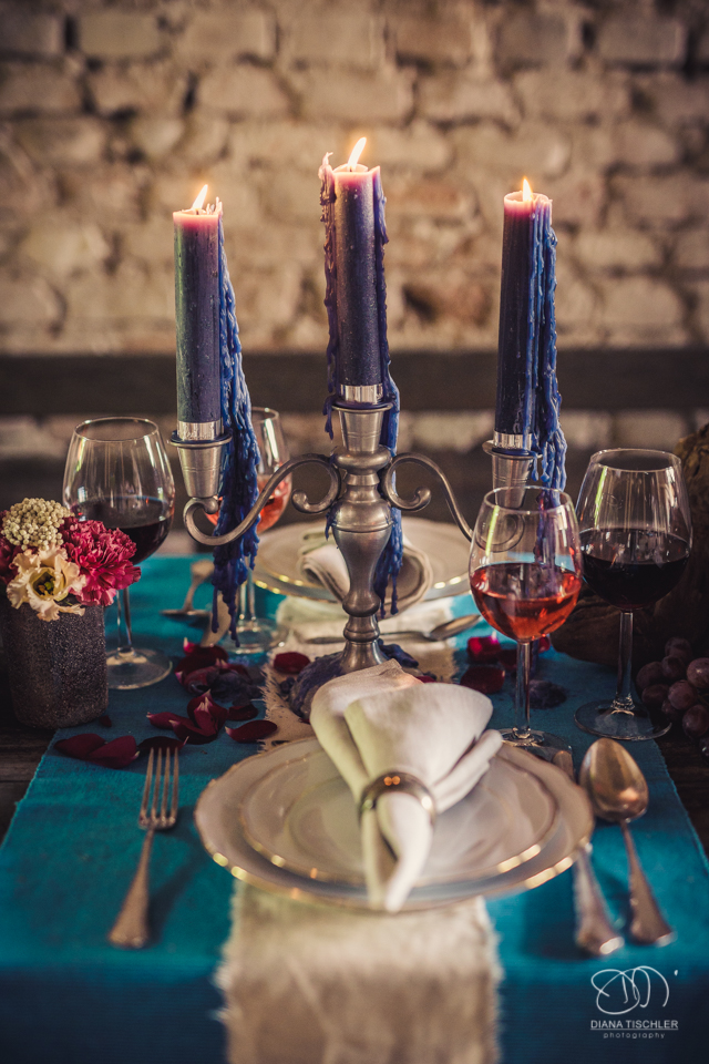 Tischgedeck und Dekoration mit Weinglaesern auf einem Vintage Esstisch fuer eine Hochzeit in einer Scheune