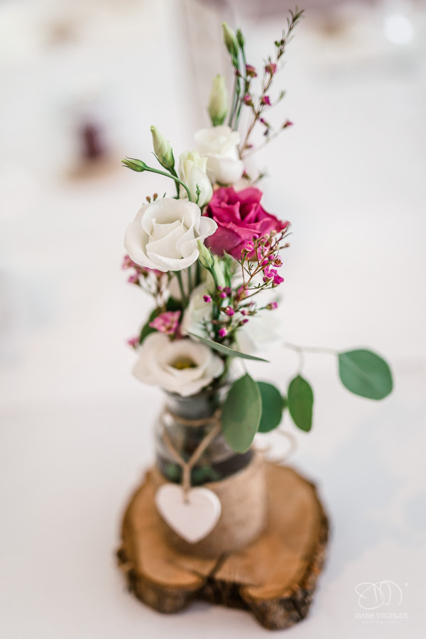 Blumendeko auf einer Baumscheibe auf dem Tisch im Festsaal bei einer Hochzeit in der WG Brackenheim