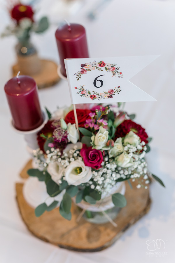 Dekoration rote Kerzen mit Blumendeko auf dem Tisch im Festsaal bei einer Hochzeit in der WG Brackenheim