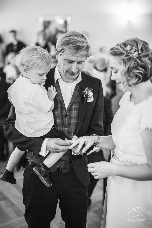 Brautpaar beim Ringwechsel mit kleinem Sohn bei einer Hochzeit in der Karlsburg Durlach