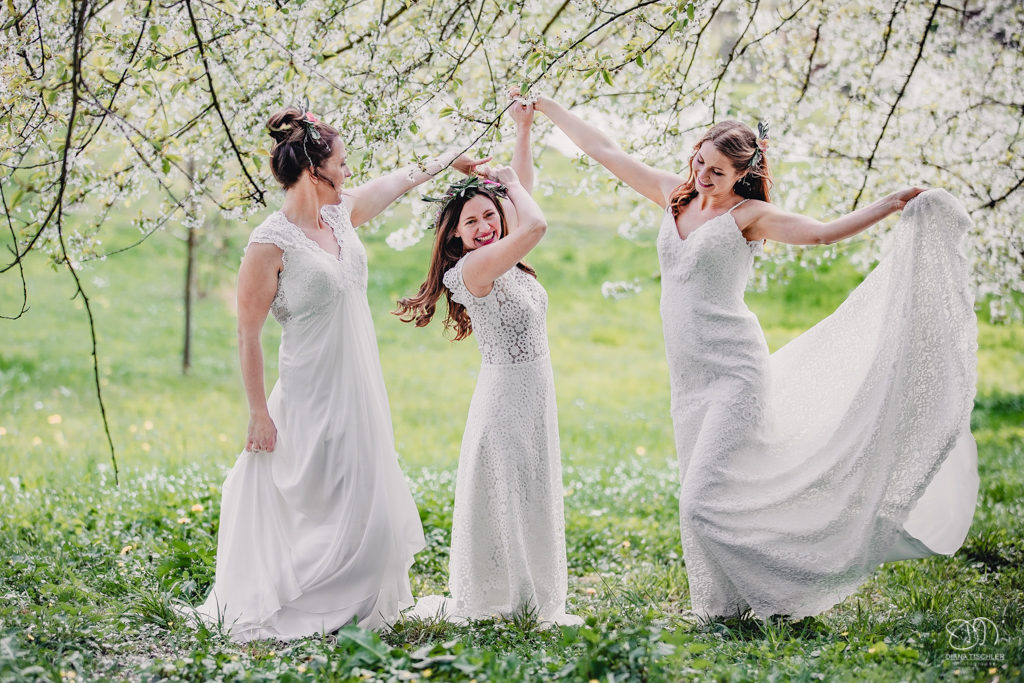 Braut Freundinnen auf Wiese unter Kirschbaum Blueten