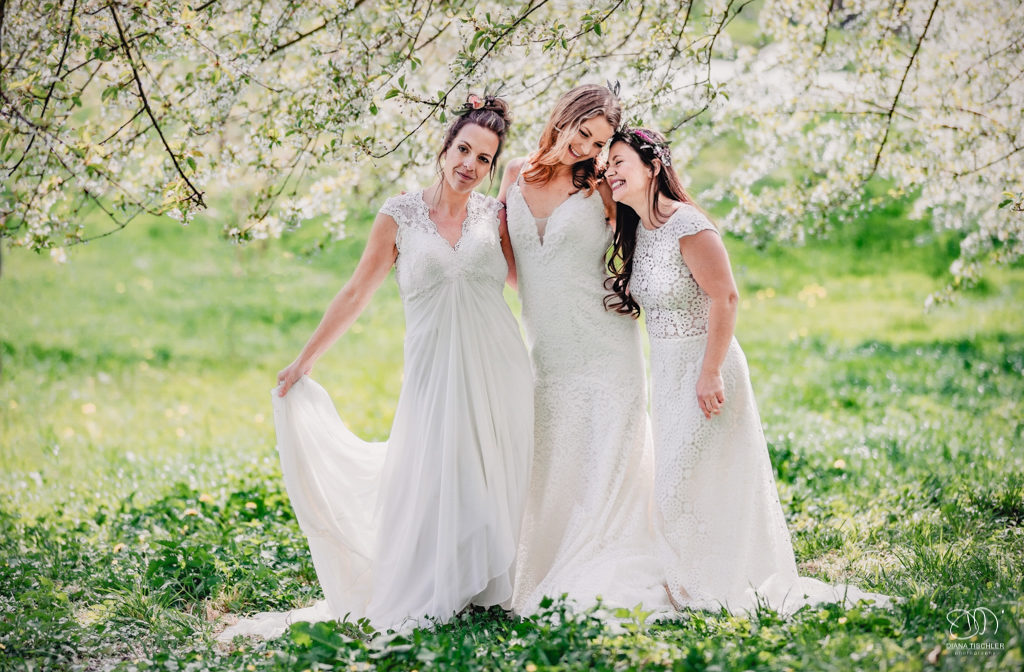 Braut Freundinnen auf Wiese unter Kirschbaum Blueten