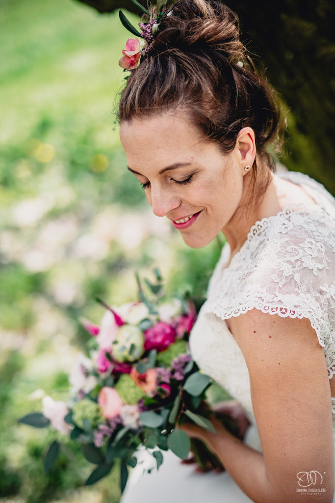 Braut mit Brautstrauss und Blumen Haarschmuck auf Wiese