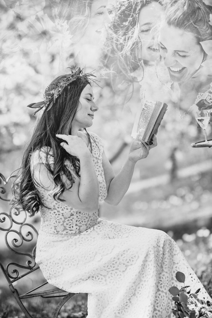 Braut mit altem Buch auf Wiese Schwarzweiss