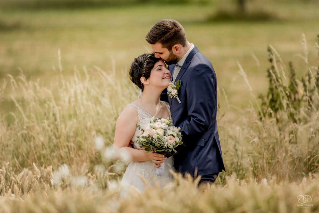 Brautpaar innig romantisch im Kornfeld auf Wiesen im Sommer Hochzeitsfotograf Karlsruhe